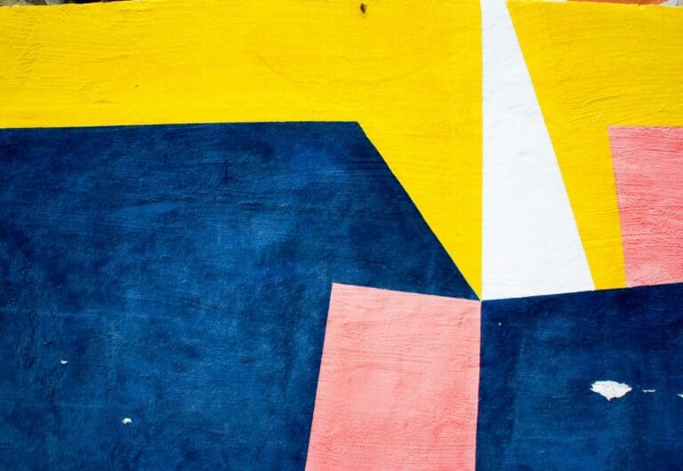 Abstract painted boards in yellow, navy, pink, and white